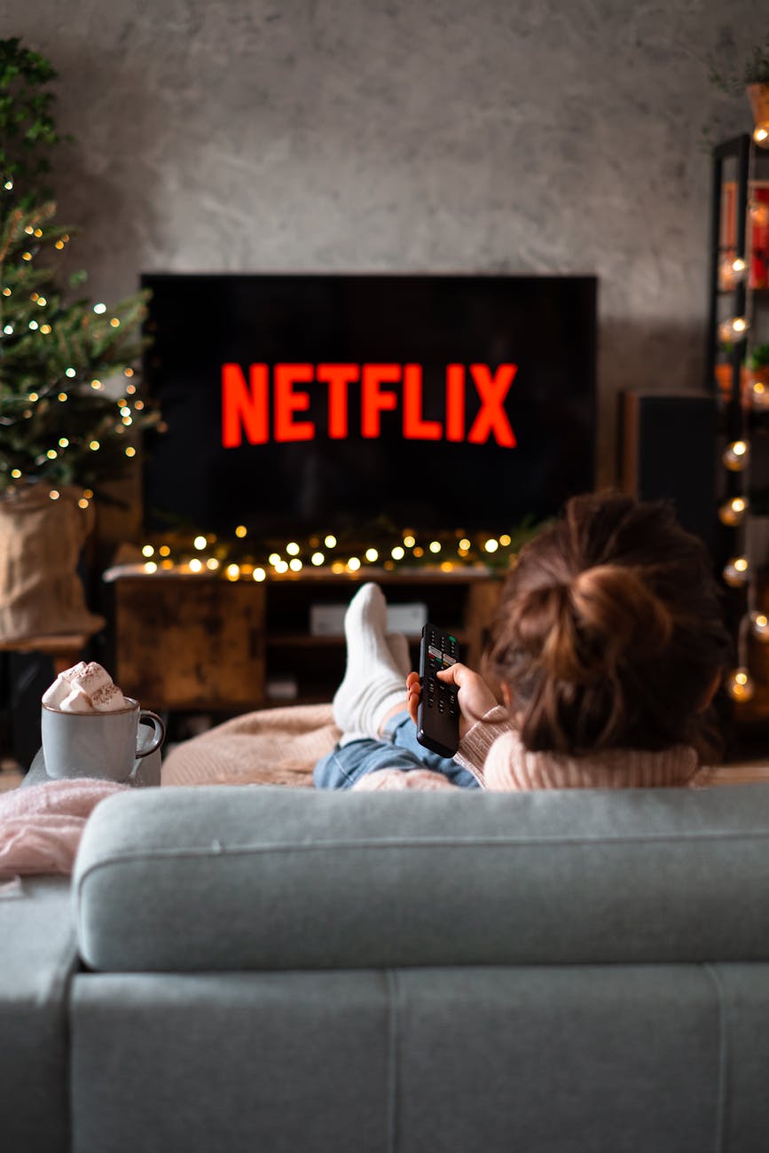 back view of a woman sitting on a sofa and watching television showing benifit of Pull Out Sleeper Sofa